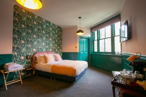 伦敦The Ship Rooms的一间卧室设有一张床和绿色的墙壁