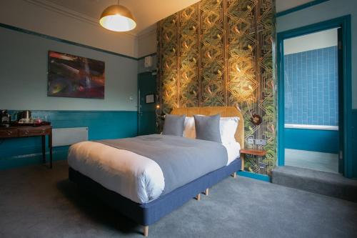 伦敦The Ship Rooms的一间卧室配有一张带蓝色墙壁的大床