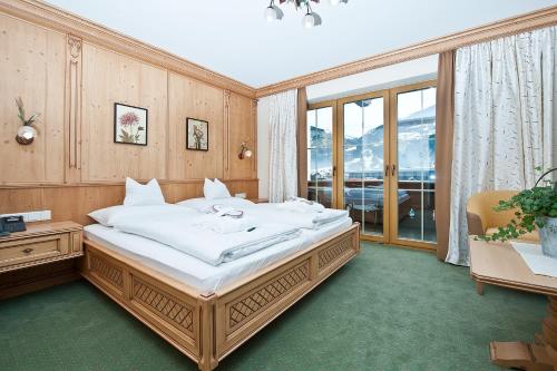 卡顿巴赫Wohlfühlhotel KERSCHDORFER - alpine hotel - garni superior- adults only的一间卧室设有一张大床和一个大窗户