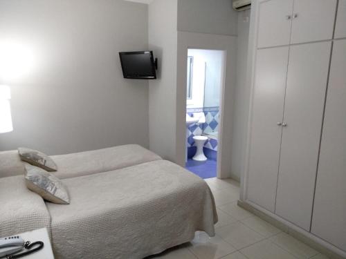 塞维利亚戈雅酒店的卧室配有一张床,墙上配有电视。
