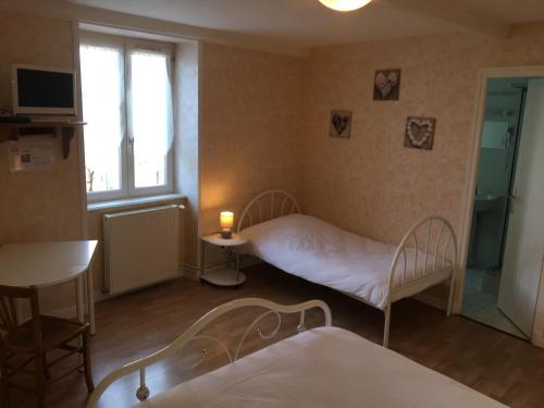 Saint-Igny-de-VersAuberge Des Petits的小房间设有两张床和窗户