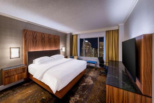 卡尔加里卡尔加里凯悦酒店的一间卧室设有一张大床和一个大窗户