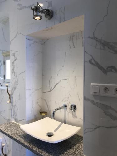 卡尔维Le Balcon du Pêcheur的浴室设有白色水槽和大理石墙壁。