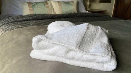 锡德茅斯Mill House - Devon Holiday Accommodation的床上的白色毛巾