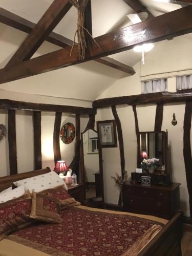代布登Ivy Todd cottage的一间卧室设有一张带木梁的大床