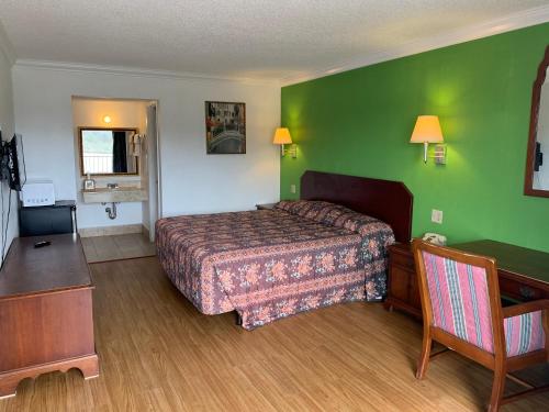 艾伦港Baton Rouge West Inn的酒店客房,设有床铺和绿色的墙壁