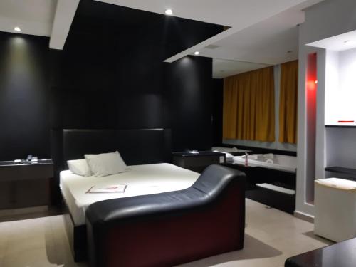 圣贝尔纳多-杜坎普Impulse Motel的一间卧室设有一张床和黑色的墙壁
