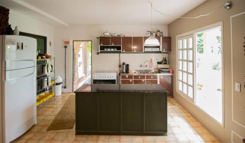 大普拉亚Acasarosa Hostel的厨房配有棕色橱柜和白色冰箱
