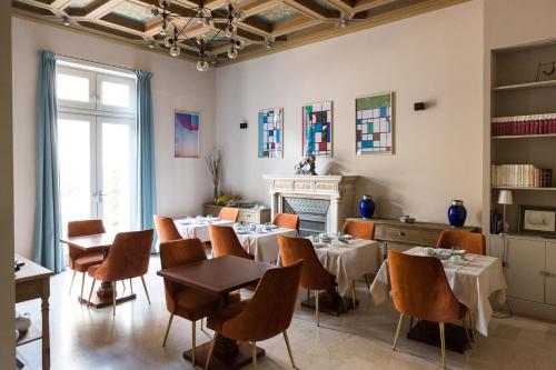 阿尔勒Hotel de l'Anglais, Guesthouse的一间带桌椅和壁炉的用餐室