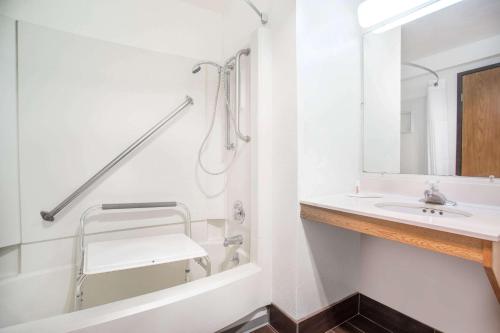 莱西莱西速8酒店的白色的浴室设有水槽和淋浴。