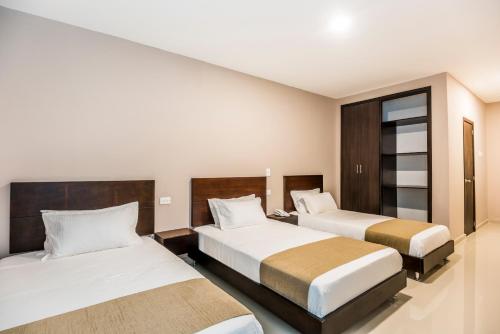 巴兰基亚Ribai Hotels - Barranquilla的酒店客房设有两张床和窗户。