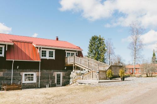 Kokemäki玛雅提拉马特卡路阿里克拖拉酒店的一座红色屋顶的房子和一个院子