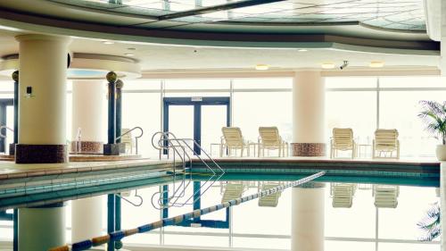 横滨横滨洲际大酒店的大楼内带椅子的游泳池