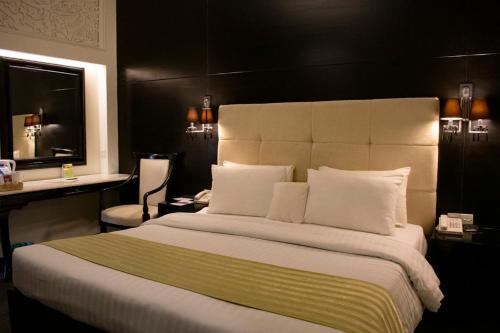 伊斯兰堡玛格拉酒店的酒店客房设有一张大床和一张书桌。