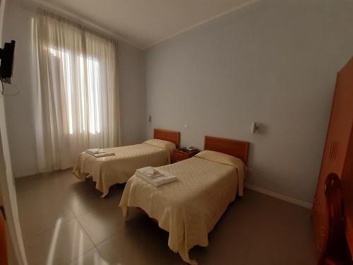 罗马Ostello Villa Monte Mario的客房设有两张床和窗户。