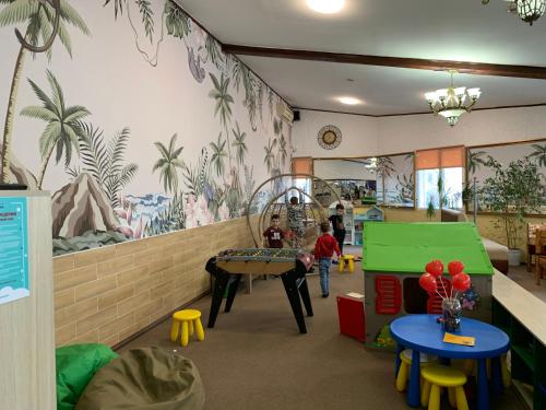 敖德萨嘉临酒店的墙上挂着棕榈树壁画的儿童房