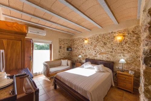 圣埃乌拉利亚埃科萨尔科乡村民宿的一间卧室,卧室内配有一张床和一把椅子