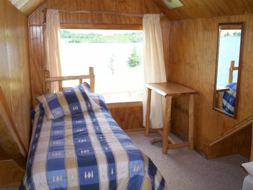 埃尔布兰科Lodge de Montaña Lago Monreal的一间小卧室,配有床和窗户