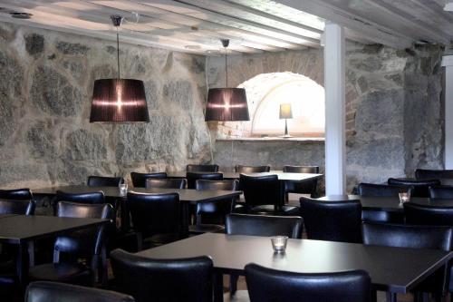 Gålö加洛斯巴德 - 假日别墅及旅舍的一间带桌椅和石墙的餐厅