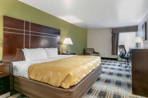 开普吉拉多Quality Inn的配有一张床和一张书桌的酒店客房