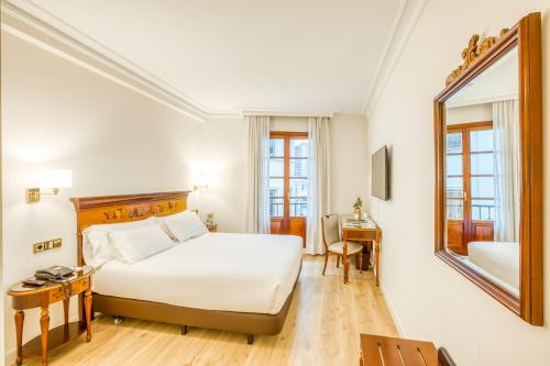 毕尔巴鄂Sercotel Arenal Bilbao的酒店客房,配有床和镜子