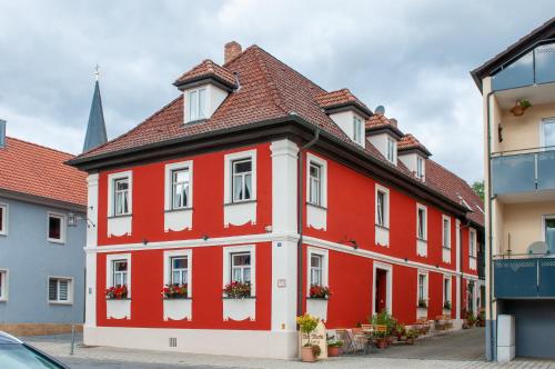 布滕汉姆Hotel Schuberths am Markt的红色和白色的建筑,窗户上摆放着鲜花