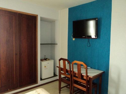 帕尔杜河畔圣若泽MAGA PLAZA HOTEL的一间设有一张桌子和两把椅子的房间,墙上设有一台电视机