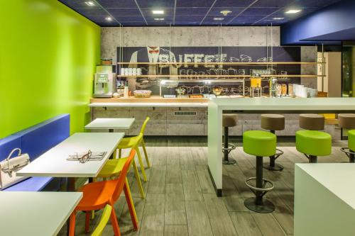莱比锡莱比锡会展中心宜必思快捷酒店的一间设有五颜六色的桌椅的快餐店
