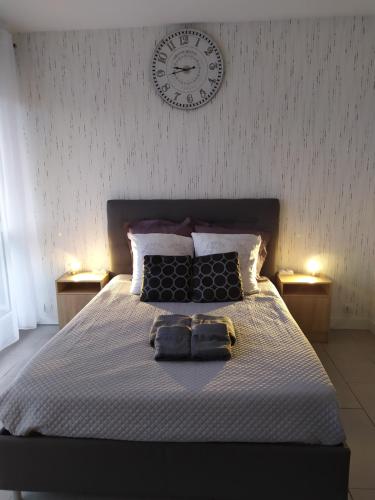桑斯Zen attitude Appt 127的床上的两条毛巾,墙上挂着一个时钟