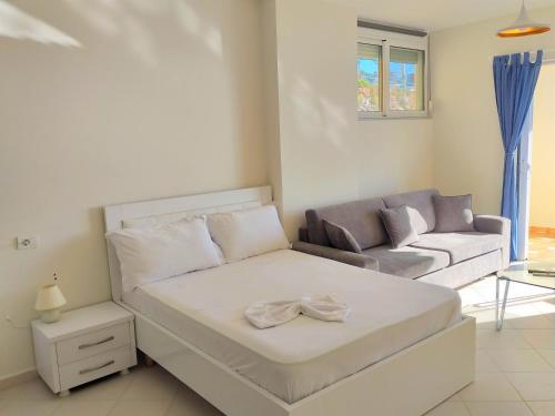 萨兰达Sail Ocean View Apartments的客厅配有床和沙发
