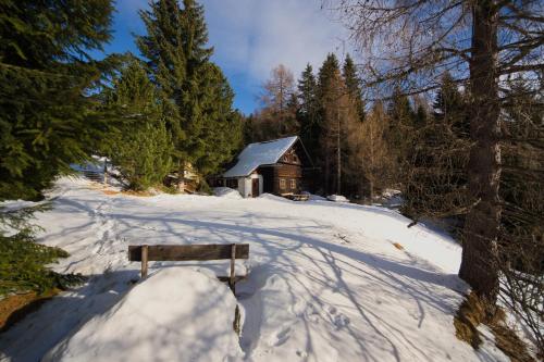 帕特加森Falkert-Hütte „Beim Almöhi"的坐在小屋前雪地里的长凳