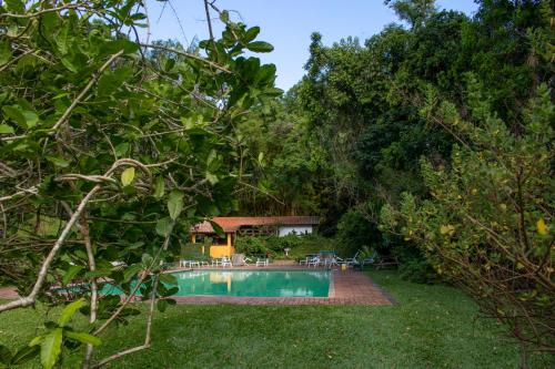 伊泰帕瓦Pousada da Alcobaça的后院设有游泳池和树木