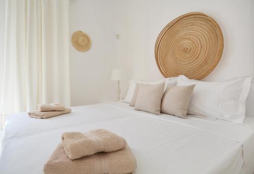 帕诺尔莫斯米科诺斯Sea Breeze Mykonos的白色的床、白色枕头和毛巾
