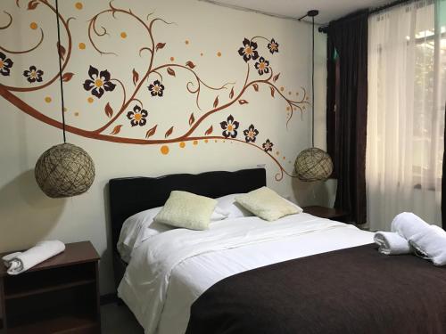 巴尼奥斯J旅馆的卧室配有一张挂着花壁画的床。