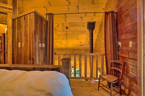 TitusvilleScenic Log Cabin with Fire Pit and Stocked Creek!的小木屋内的卧室,配有一张床和椅子