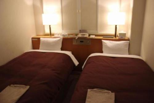 高山Country Hotel Takayama - Vacation STAY 67711的配有两盏灯的小房间内的两张床