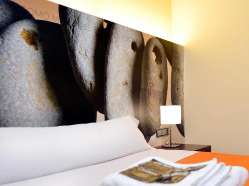 萨莫拉Hostal Bajo La Muralla的一间卧室配有一张壁画床