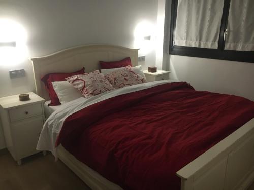 蒙希亚Urrumendi的卧室配有一张大床,提供红色床单和枕头