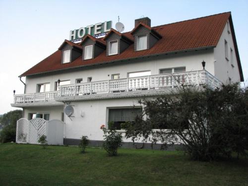 Knüllwald林登酒店的一座白色的大建筑,有红色的屋顶