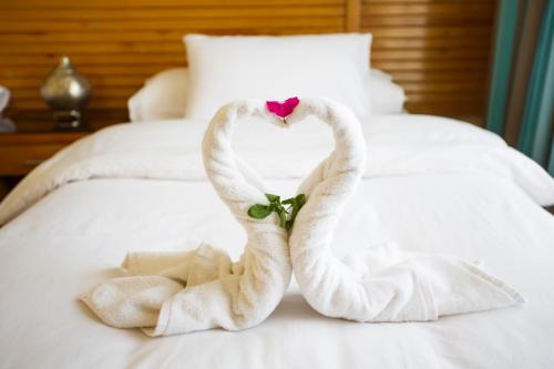 达哈布谢赫阿里达哈卜度假村的两条毛巾,形状像天鹅,坐在床上
