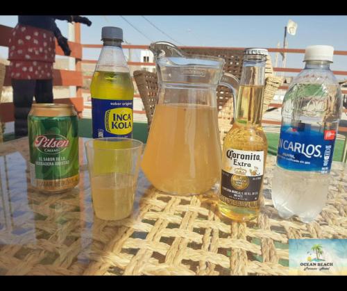 帕拉卡斯Hotel Ocean Beach Paracas的一张桌子,上面放有瓶装饮料和一杯水