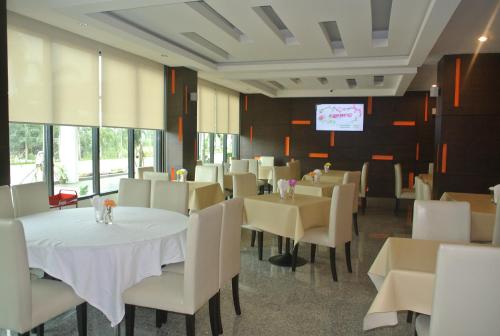 素叻S塔拉大酒店的用餐室配有白色的桌子和白色的椅子
