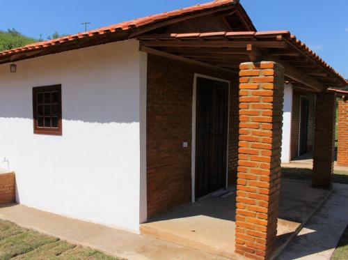 布埃诺布兰当Chalés Cachoeira Cafundó的白色的小房子,设有木屋顶