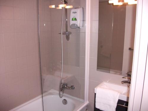 维特雷勒敏诺特尔酒店的带淋浴、浴缸和盥洗盆的浴室