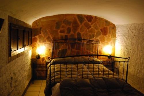 巴萨Cueva El Haro的一间卧室配有一张石墙床