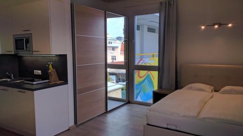 克拉根福211 Amsterdam, Studio Apartment, 30m2 1-4 Pers的一间卧室配有一张床,厨房设有阳台