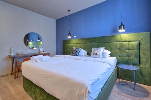 巴尼亚卢卡Boutique Hotel St Georgije的一间卧室配有一张大床和绿色床头板