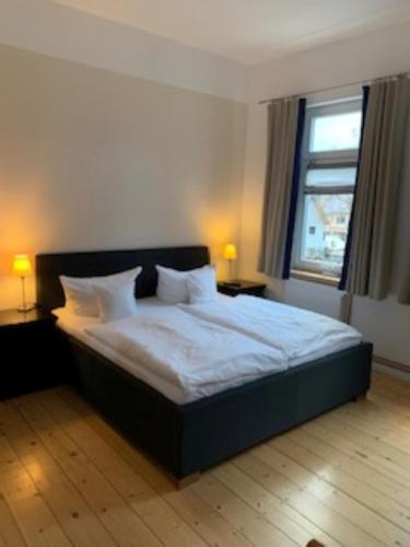 布劳恩拉格Appartment 5的一间卧室配有一张带白色床单的床和一扇窗户。