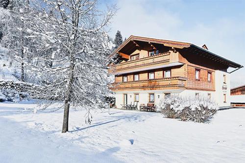 弗拉绍Appartements Oberhof的雪中大木房子,有树