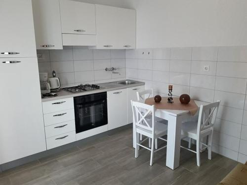斯维蒂尤拉伊Delfin Apartments的白色的厨房配有桌椅
